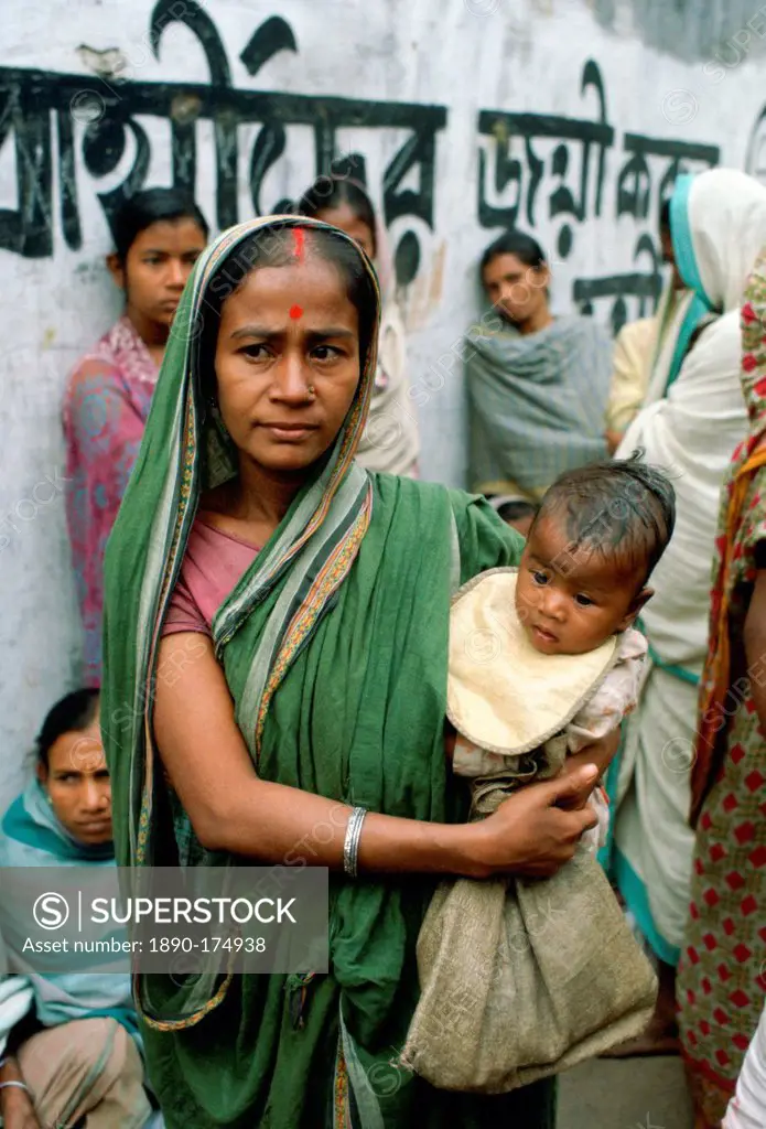 A mother carrying her child and queuing for food handouts withother women at Mother Teresa's Mission in Calcutta, India