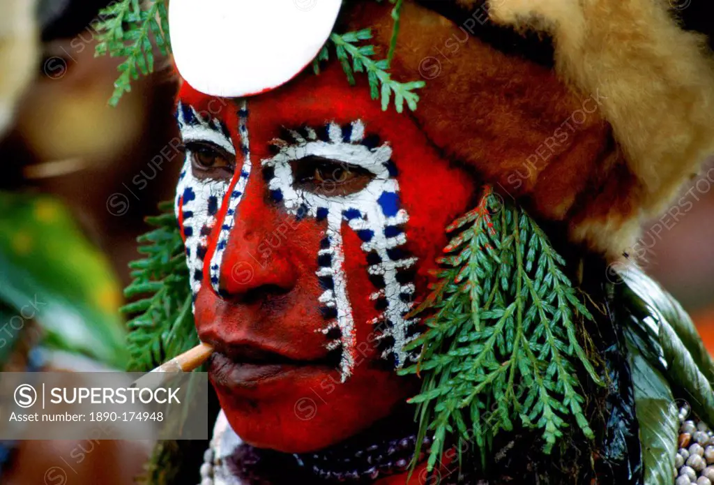 Tribesman with painted face and a cigarette in Papua New Guinea