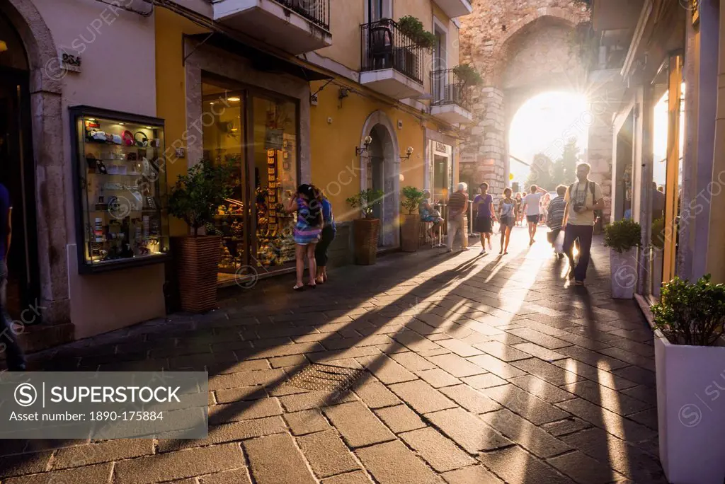 Tourists entering Corso Umberto, the main street in Taormina at sunset, Sicily, Italy, Europe