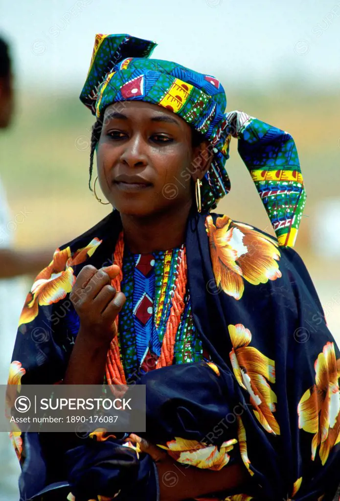 Nigerian woman in brightly coloured clothes and with the traditional face markings.