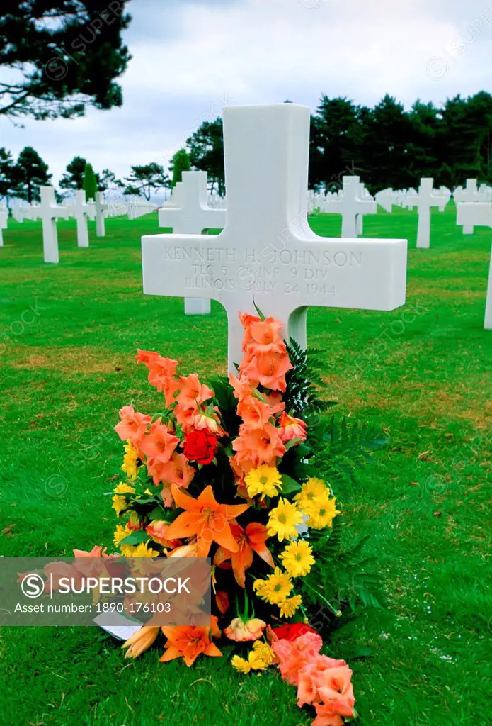 Headstones at a United States Military Cemetery at Utah Beach in Normandy, France. Flowers have been left beside one of the crosses dedicated to a US ...