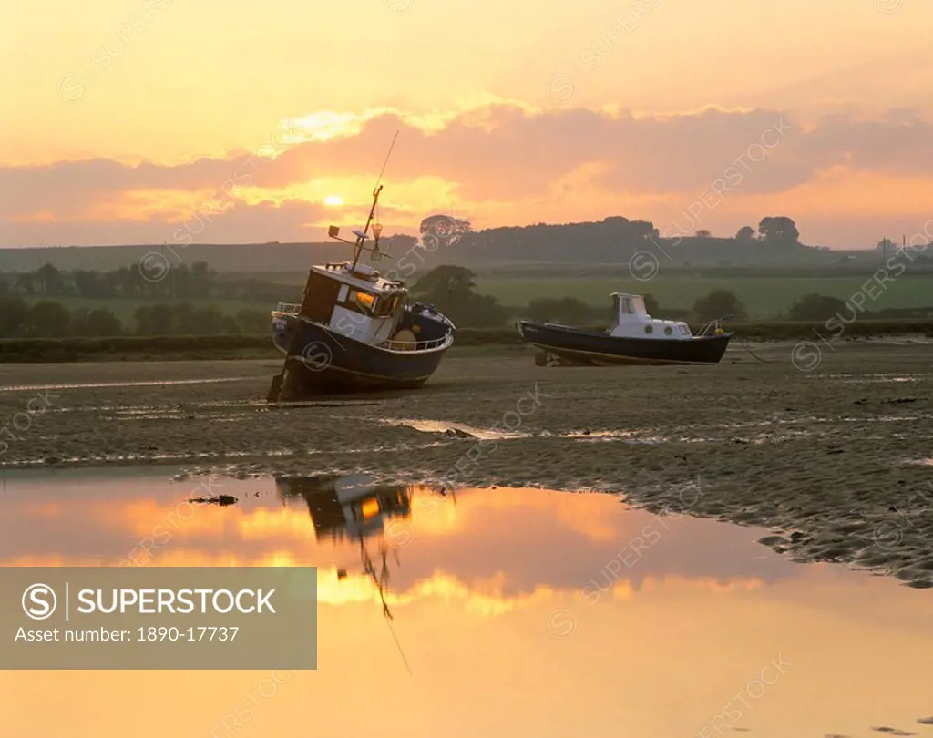 Fishing boat at sunset on the Aln estuary at low tide, Alnmouth, Northumberland, England, United Kingdom, Europe
