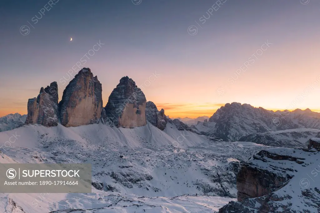 Sunset over Tre Cime di Lavaredo and Monte Cristallo covered with snow in autumn, Dolomites, border of South Tyrol and Veneto, Italy, Europe