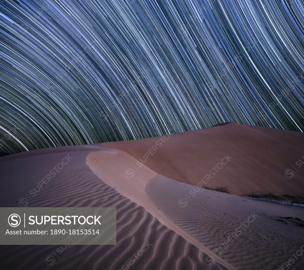 Equatorial star trail above sand dunes in the Rub al Khali desert, Oman, Middle East