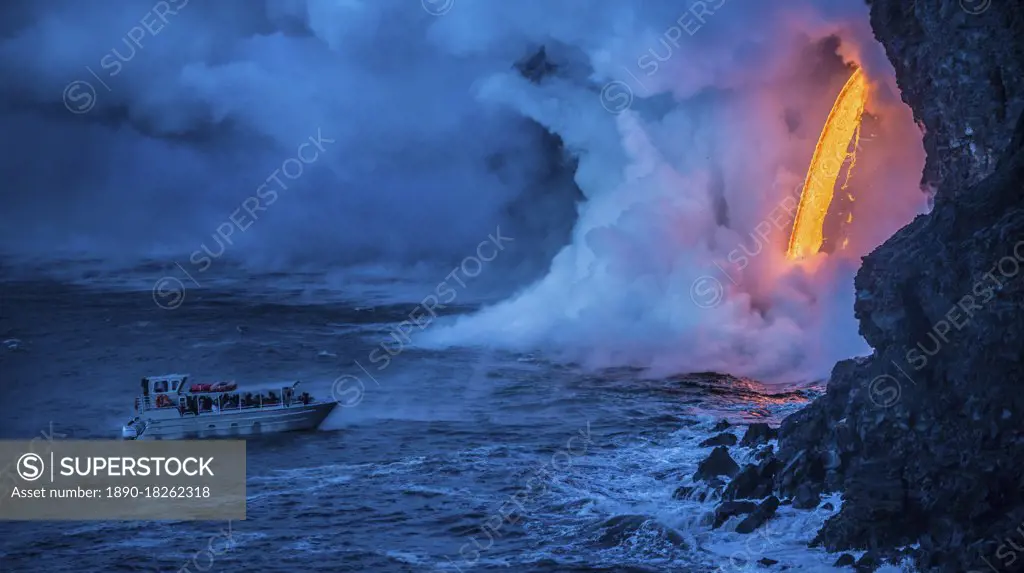 A tour boat observes lava pouring into the sea from 60 feet above as steam plumes billow up, Hawaii Volcanoes National Park, UNESCO World Heritage Site, Hawaii, United States of America, Pacific