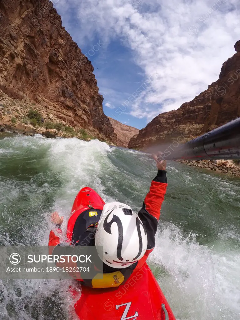 Skip Brown surfs his whitewater kayak on a glassy standing wave on the Colorado River through the Grand Canyon, Arizona, United States of America, North America