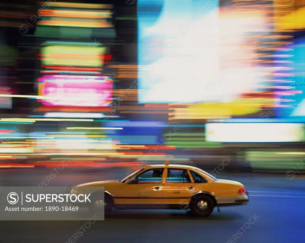 Yellow cab driving past blurred neon lights at night in Times Square in New York, United States of America, North America