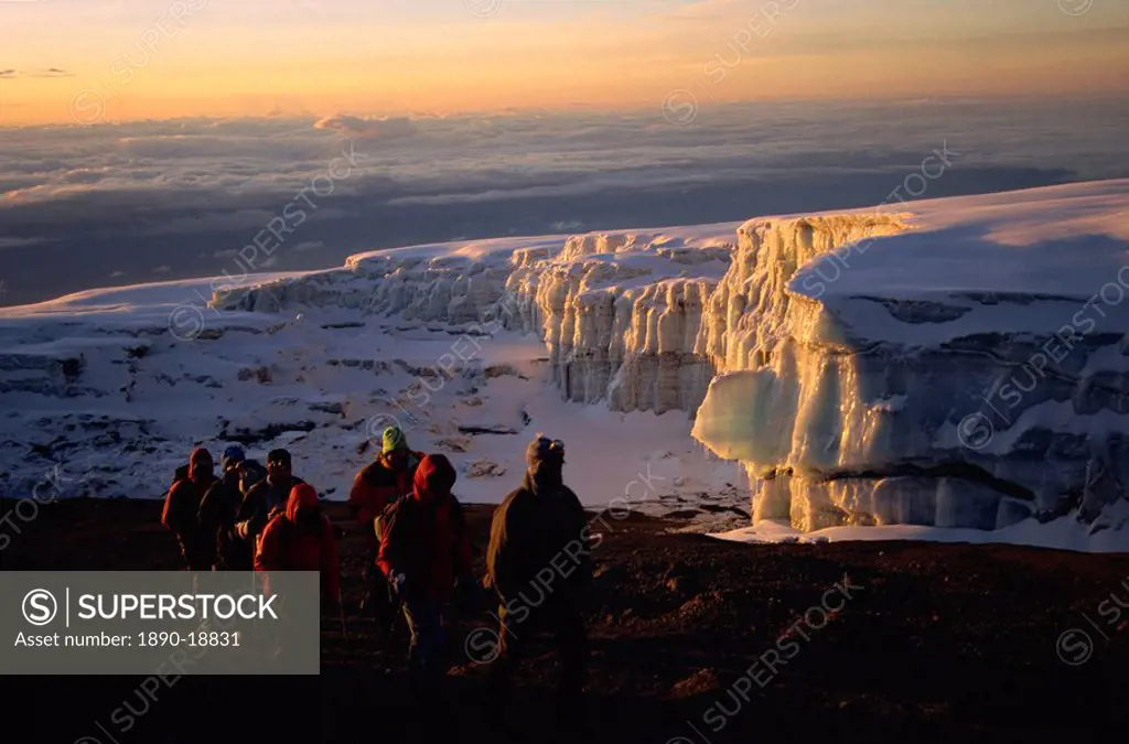 Trekkers and glacier at sunrise on summit of Kibo, 5895m, Kilimanjaro National Park, Tanzania, East Africa, Africa