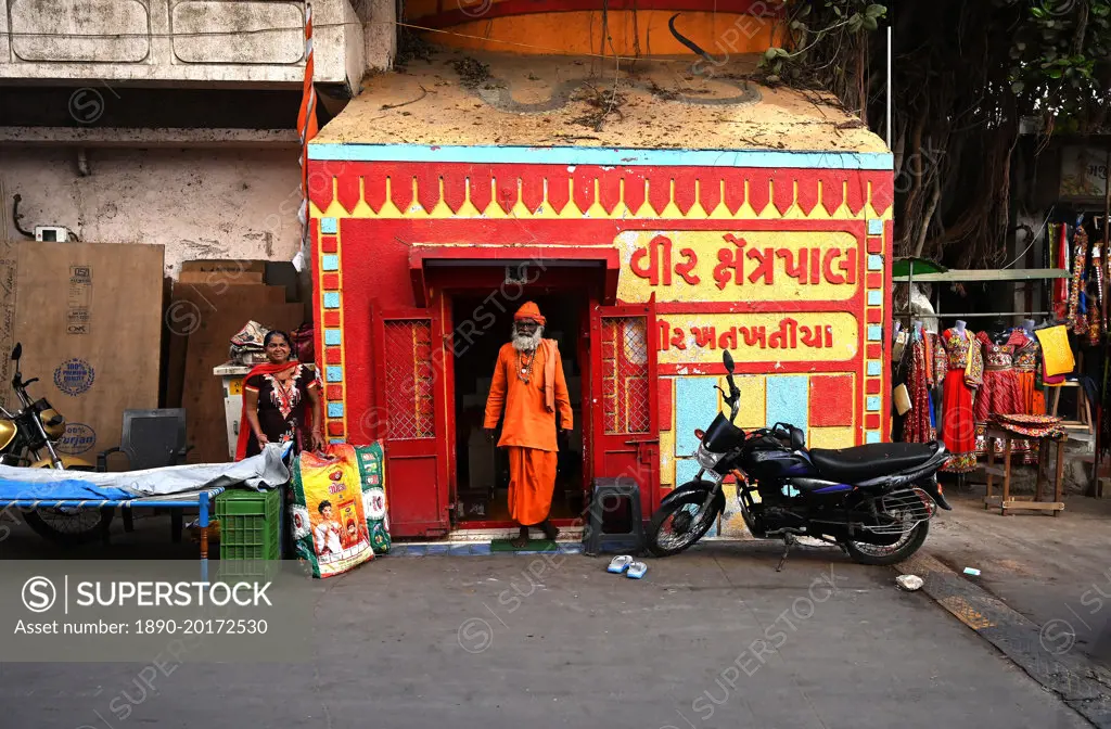 Hindu pundit dressed in holy orange at tiny Hindu temple near Gomati ghat, Dwarka, Gujarat, India, Asia
