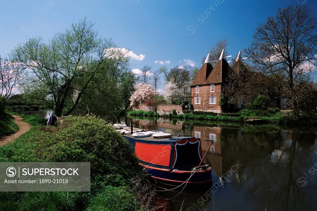 Brightly painted barge and oast houses on the River Medway, Yalding, near Maidstone, Kent, England, United Kingdom, Europe