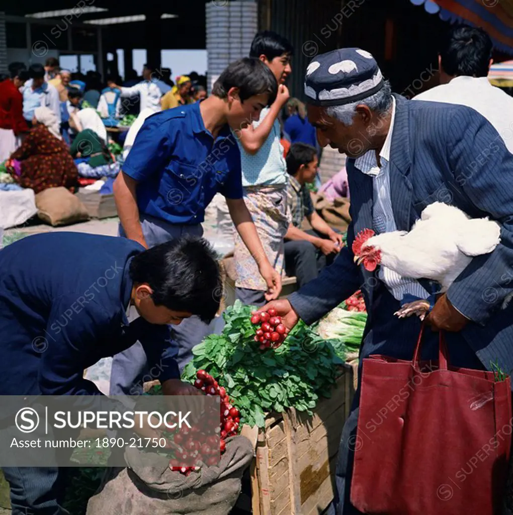 Uzbek man with chicken buying radishes in the central market in the city of Samarkand, Uzbekistan, Central Asia, Asia
