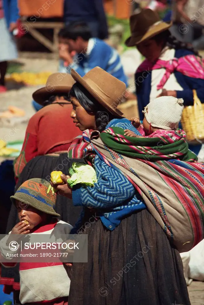 Portrait of a woman in a felt hat with her children in the Sunday market at Pisac in Peru, South America