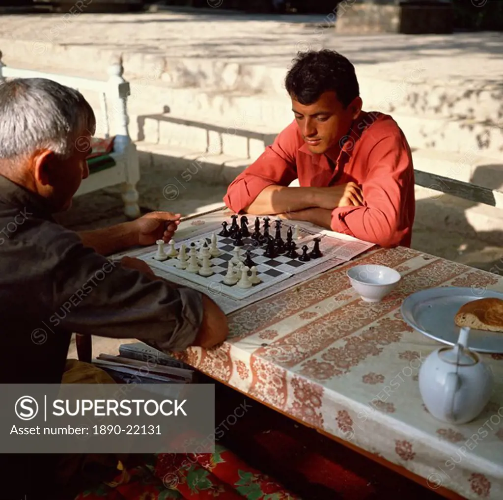 Uzbek men playing chess in a tea house garden, Bukhara, Uzbekistan, Central Asia, Asia