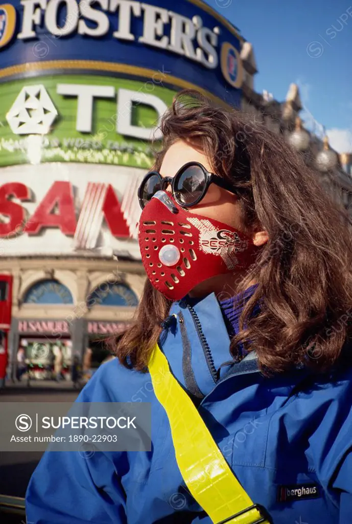 Female cyclist wearing a carbon filtered pollution mask, Piccadilly Circus, London, England, United Kingdom, Europe