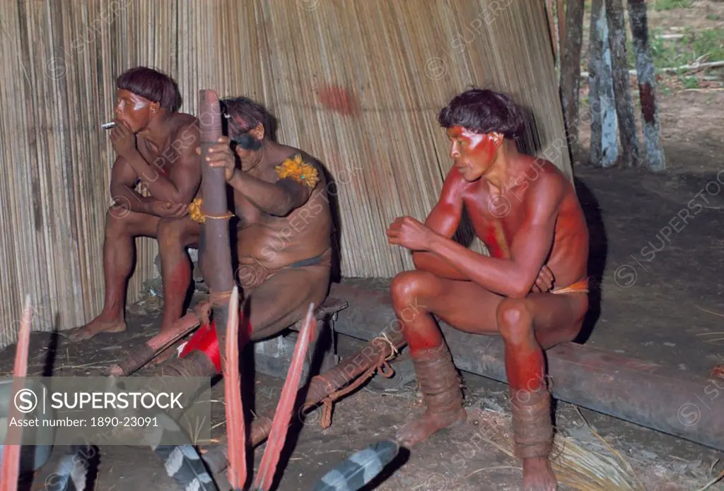Kamayura Indians playing flutes inside hut, Xingu area, Brazil, South America