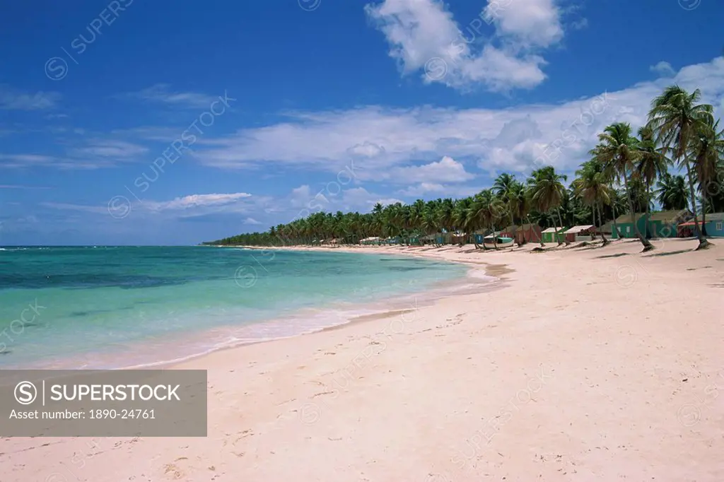 Beach huts and palm trees line an empty beach on Saona Island, Dominican Republic, West Indies, Caribbean, Central America