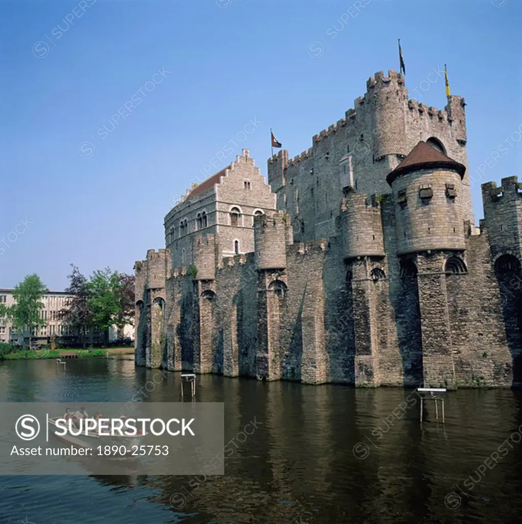 Small tourist boat passing the Castle of the Counts of Flanders in the city of Ghent, Belgium, Europe