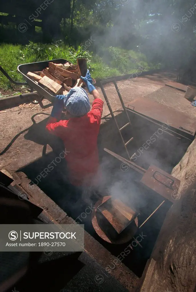 Stoking the smokehouse furnaces for smoking salmon, Scotland, United Kingdom, Europe