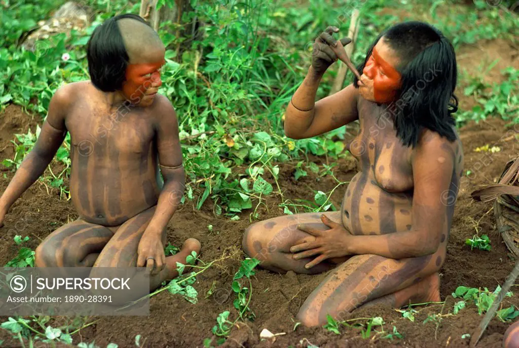 Portrait of a Xingu woman and child with body decoration in Brazil, South America