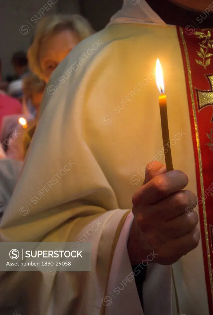 Close_up of a priest´s hand holding a candle during Mass in Easter week, Church of the Holy Sepulchre, Old City, Jerusalem, Israel, Middle East