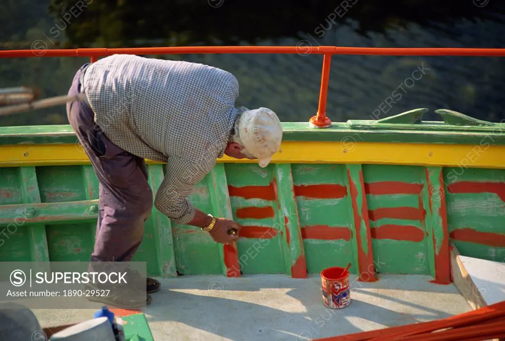 Man painting the inside of a boat on Malta, Europe