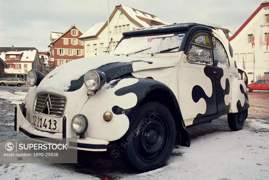 2CV car painted crazy cow, covered in snow