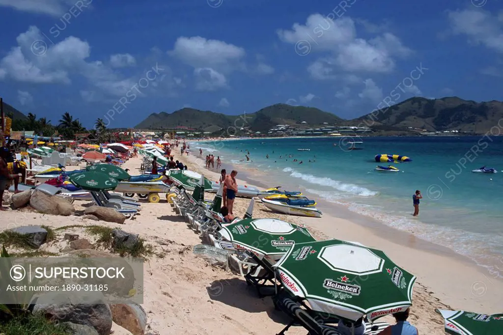 Tourists on loungers under parasols or beach umbrellas on Orient Beach, St. Maarten St. Martin, Leeward Islands, French West Indies, Caribbean, Centra...