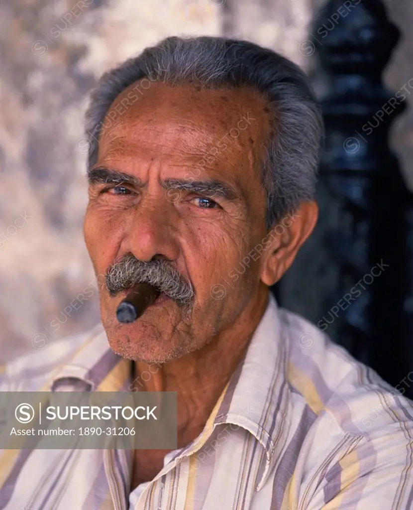 Head and shoulders portrait of an eldery man with moustache smoking a cigar, looking at the camera, Habana Havana, Cuba, West Indies, Caribbean, Centr...