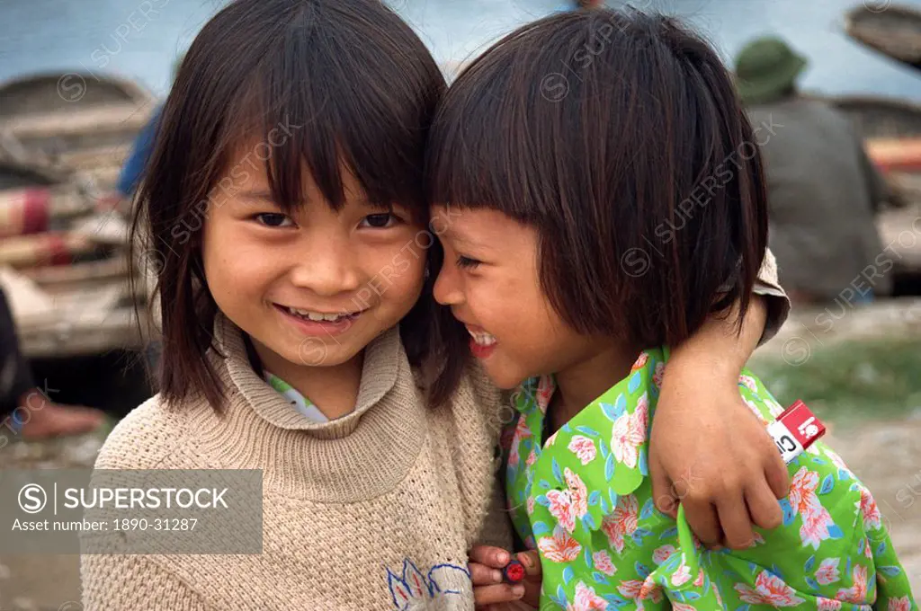 Head and shoulders portrait of two little Vietnamese girls, smiling, one looking at the camera, in Hoa Lu, Vietnam, Indochina, Southeast Asia, Asia