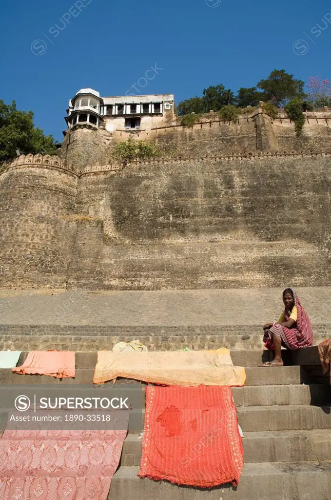 Drying washing with Ahilya Fort behind, now a heritage hotel, on the banks of the Narmada River, Maheshwar, Madhya Pradesh state, India, Asia
