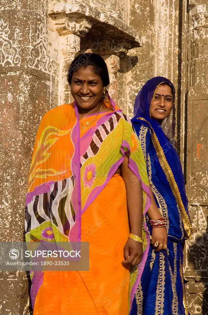 Two women visiting a small Hindu temple in middle of the Narmada River, Maheshwar, Madhya Pradesh state, India, Asia