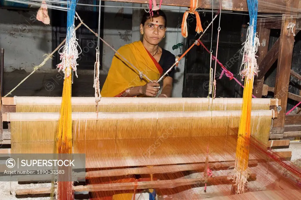 A woman weaving at one of the cooperatives in an area that is famous for its saris, Maheshwar, Madhya Pradesh state, India, Asia