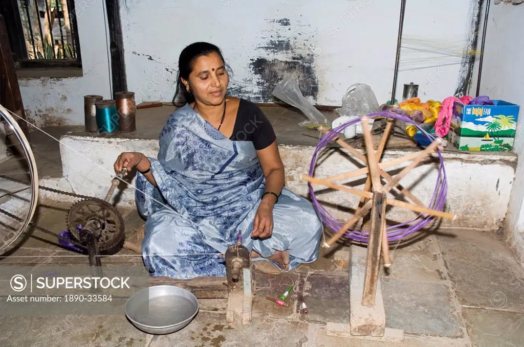 A woman spinning at one of the cooperatives in an area that is famous for its saris, Maheshwar, Madhya Pradesh state, India, Asia
