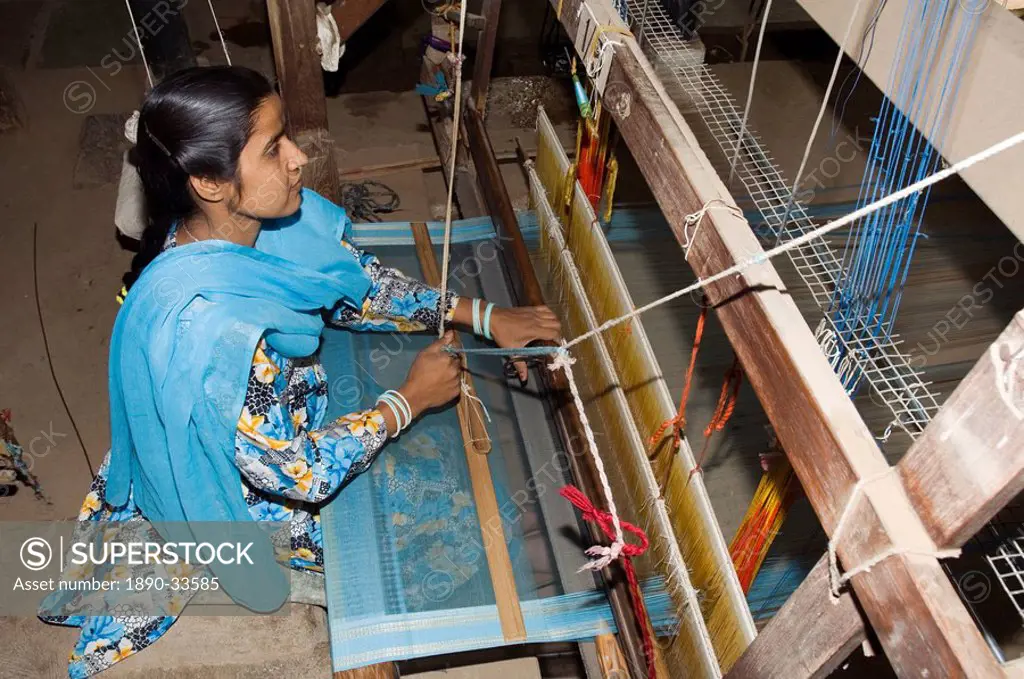 A woman weaving at one of the cooperatives in an area that is famous for its saris, Maheshwar, Madhya Pradesh state, India, Asia