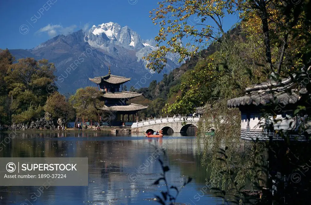Black Dragon Pool park with bridge and pagoda, and mountains in the background at Lijiang, Yunnan Province, China, Asia