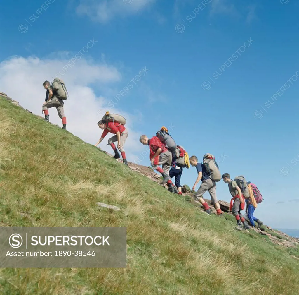 Backpackers scrambling, Pen y Fan, Brecon Beacons, Powys, Wales, United Kingdom, Europe