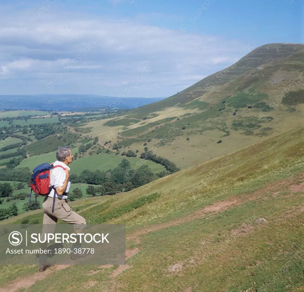 Man ascending Y Grib with Mynydd Bychan in the background, The Black Mountains, Powys, Wales, United Kingdom, Europe