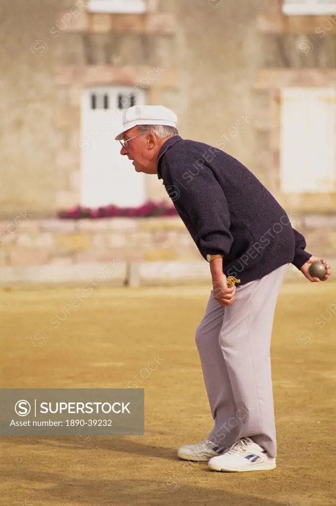 Portrait of an elderly French man in casual clothing, wearing trainers, playing petanques in Brittany, France, Europe