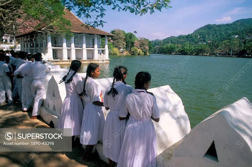 Girls standing on the edge of the artificial lake, Kandy, Sri Lanka, Asia