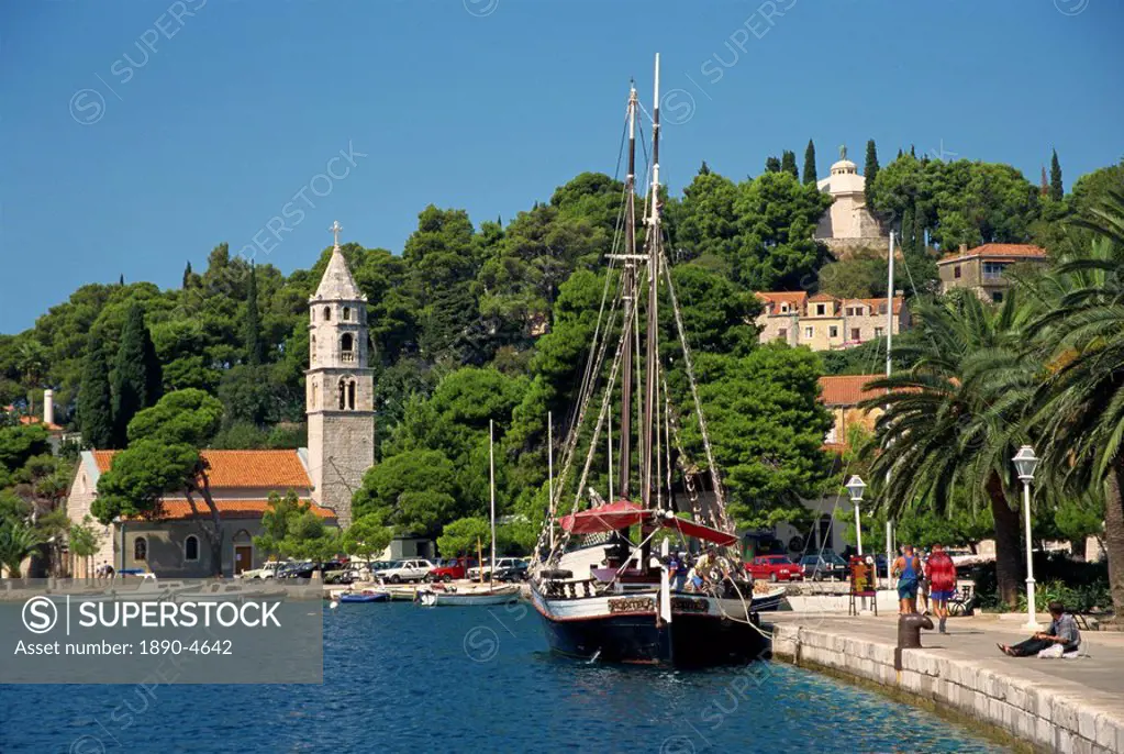 Sailing boat on the waterfront, with trees and church in the background at Cavtat, Dalmatian Coast, Croatia, Europe