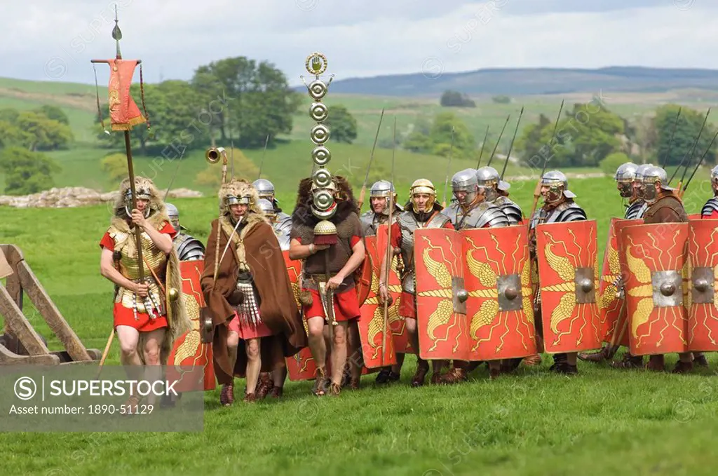 Roman soldiers of the Ermine Street Guard, marching in column led by Standard Bearers and Trumpeter, Birdoswald Roman Fort, Hadrians Wall, Northumbria...