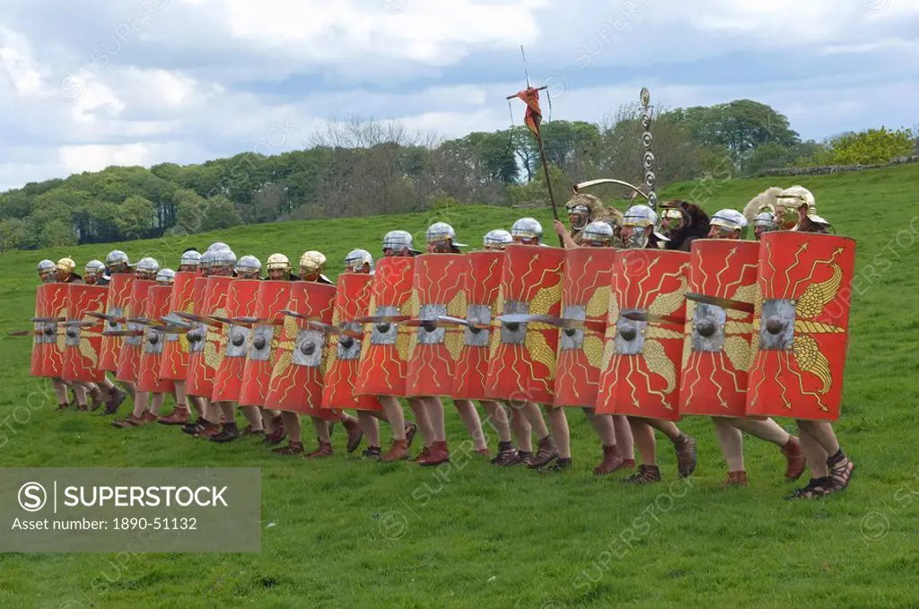 Roman soldiers of Ermine Street Guard, in line abreast with shields and stabbing swords, cavalry in support, Birdoswald Roman Fort, Hadrians Wall, Nor...