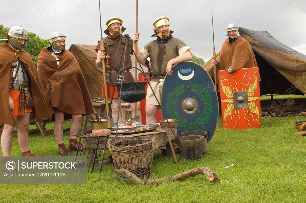 Roman soldiers of the Ermine Street Guard in encampment relaxing around the campfire, Birdoswald Roman Fort, Hadrians Wall, Northumbria, England, Unit...