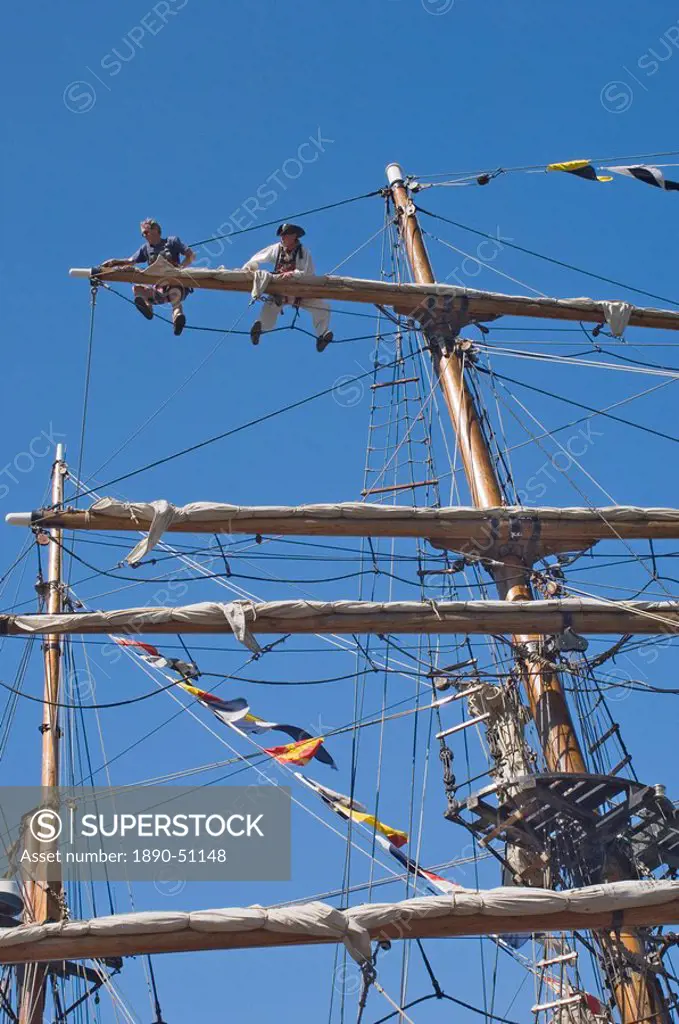 Detail of main mast of tall ship with two seamen on top yard securing sail, Whitehaven, Cumbria, England, United Kingdom, Europe
