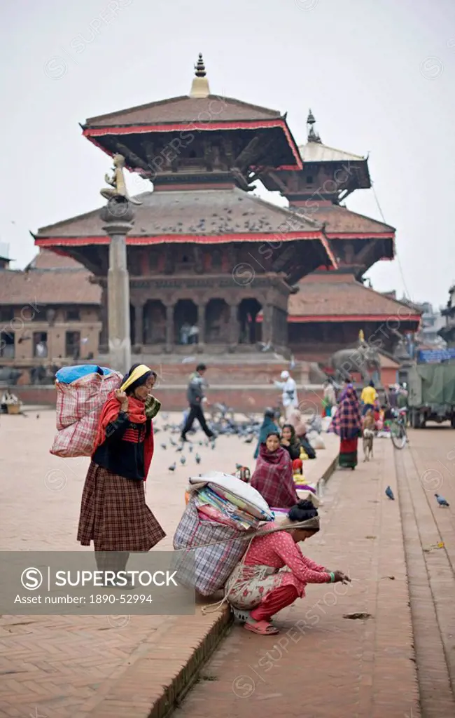 Women loading up, using dokos to carry loads, in Durbar Square, Patan, Kathmandu Valley, Nepal, Asia
