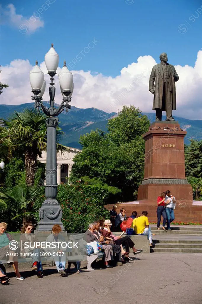 People sitting on benches near a statue of Lenin in Yalta, the Crimea, Ukraine, Europe