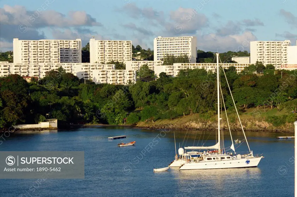High rise residential blocks overlooking Scholerher Bay, with moored sailing boat, Martinique, Windward Islands, West Indies, Caribbean, Central Ameri...