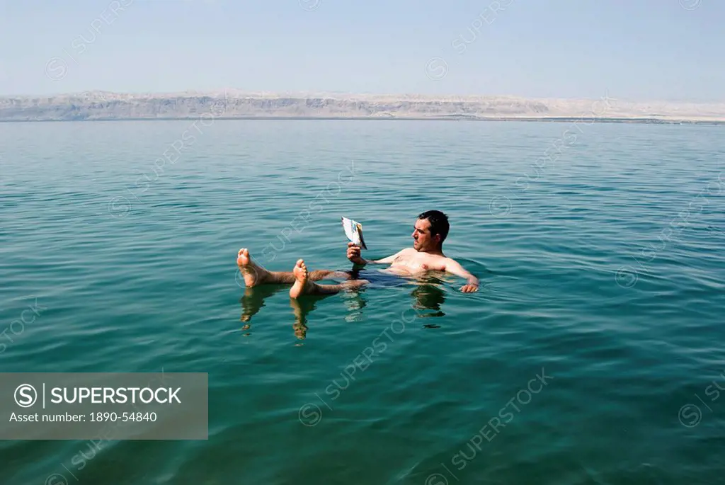 Tourist reading a book, Dead Sea, Jordan, Middle East
