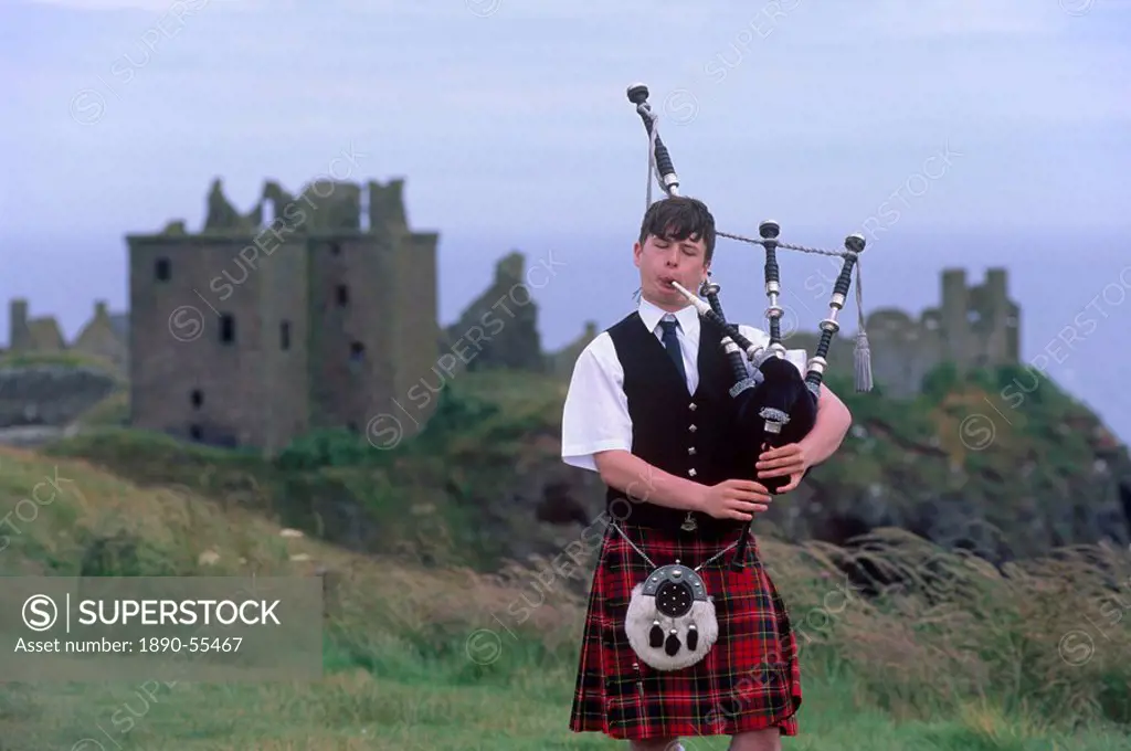 Piper playing, in front of Dunnotar Castle dating from the 14th century, near Stonehaven, Aberdeenshire, Scotland, United Kingdom, Europe