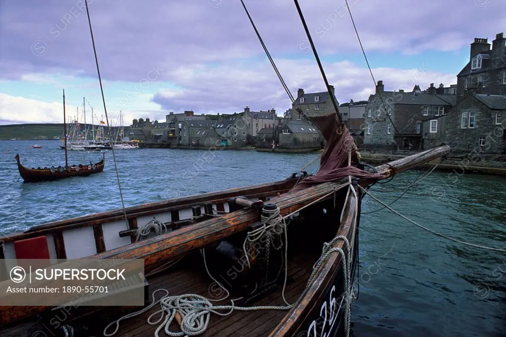 Lerwick seafront, with wharves and slipways, and stone warehouses lodberries, from a zulu replica, with Viking ship replica on left, Shetland Islands,...